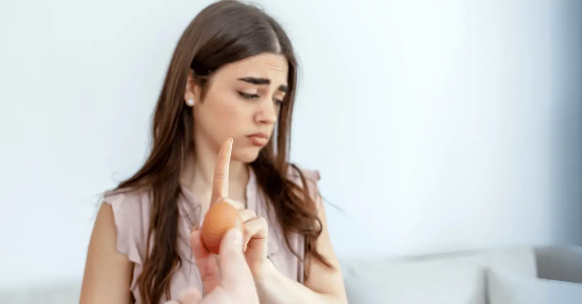 Woman, putting her hand up to say no thanks to eggs, as the featured image for article about food allergies vs food sensitivity vs food intolerance.