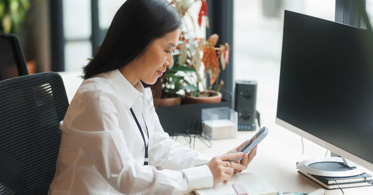 Woman checking her monthly cell statement with pen in hand. Learn how to save on your cell phone bill effectively.